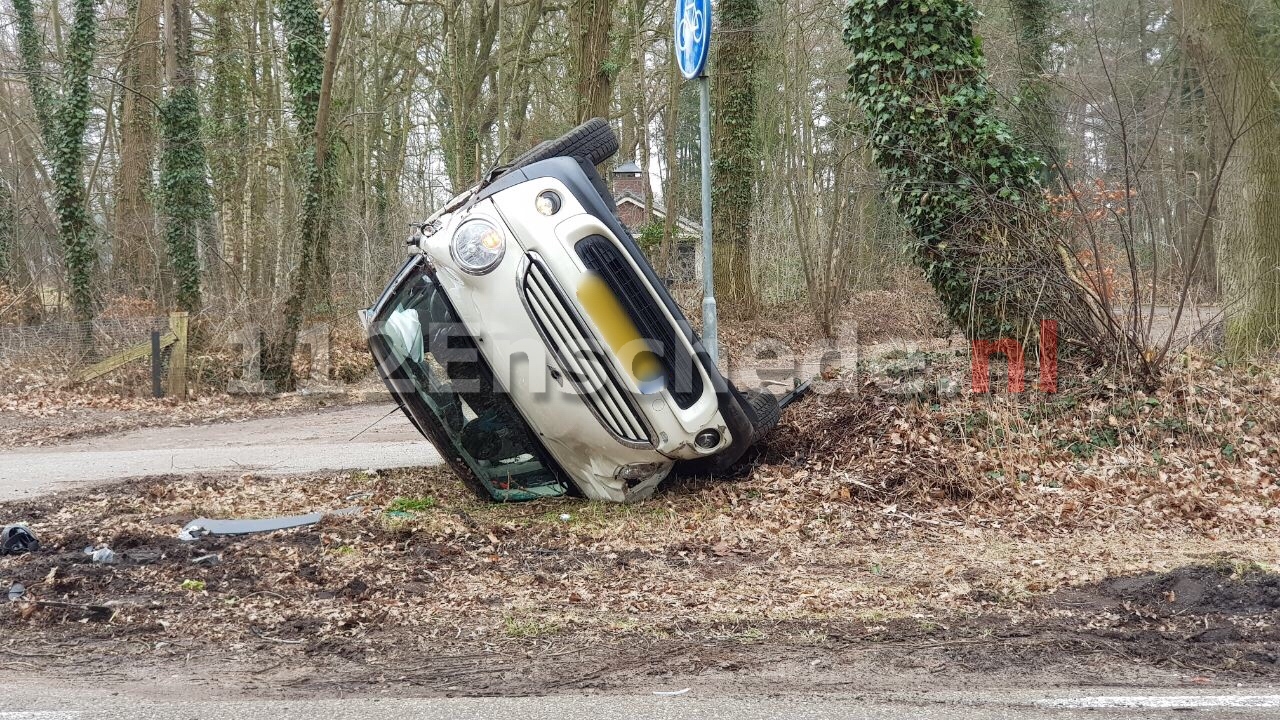 Auto op de kop tegen verkeersbord na aanrijding in Enschede