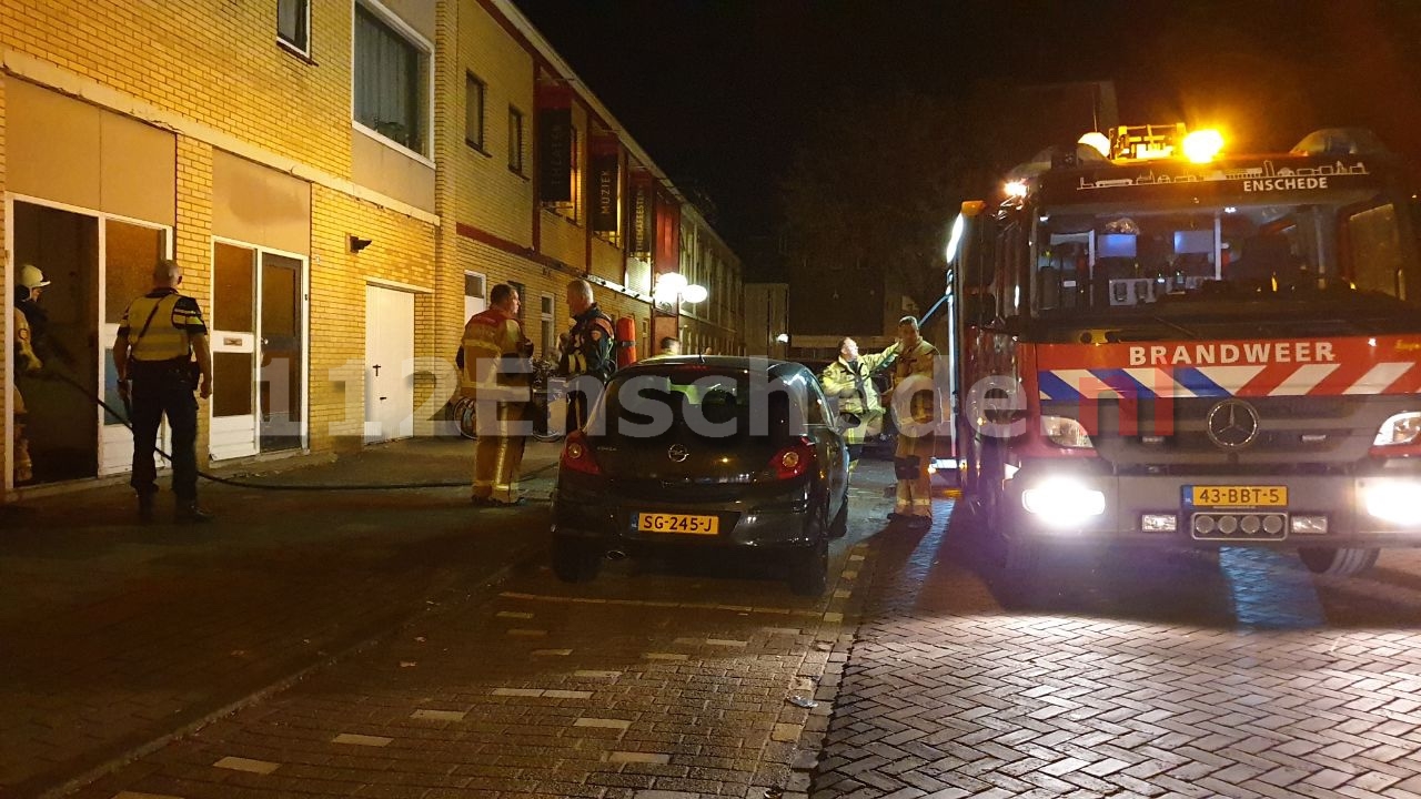 Coniferen in brand achter appartementencomplex in Enschede