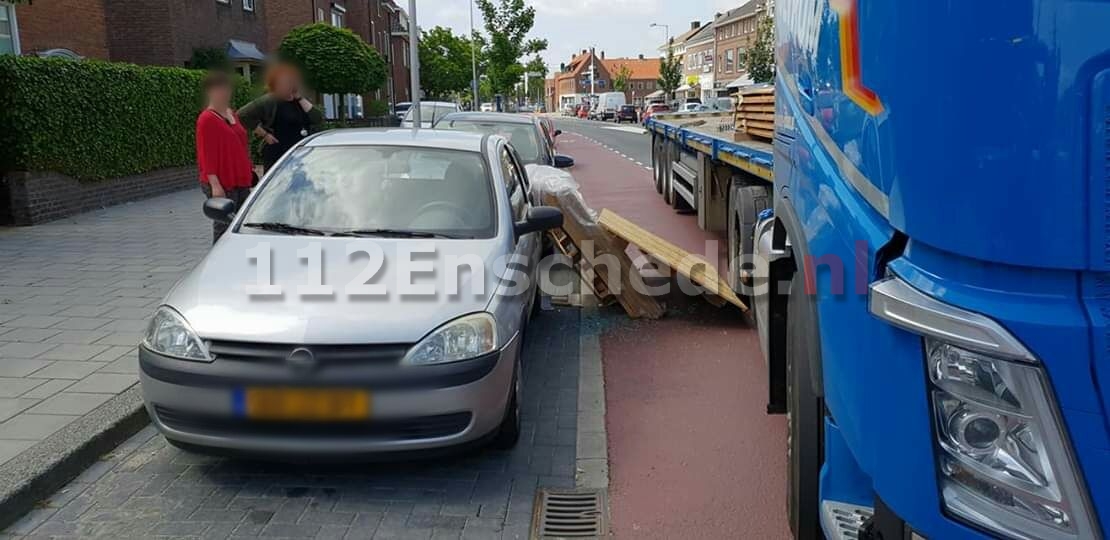 Lading valt van vrachtwagen en beschadigd twee auto’s in Enschede