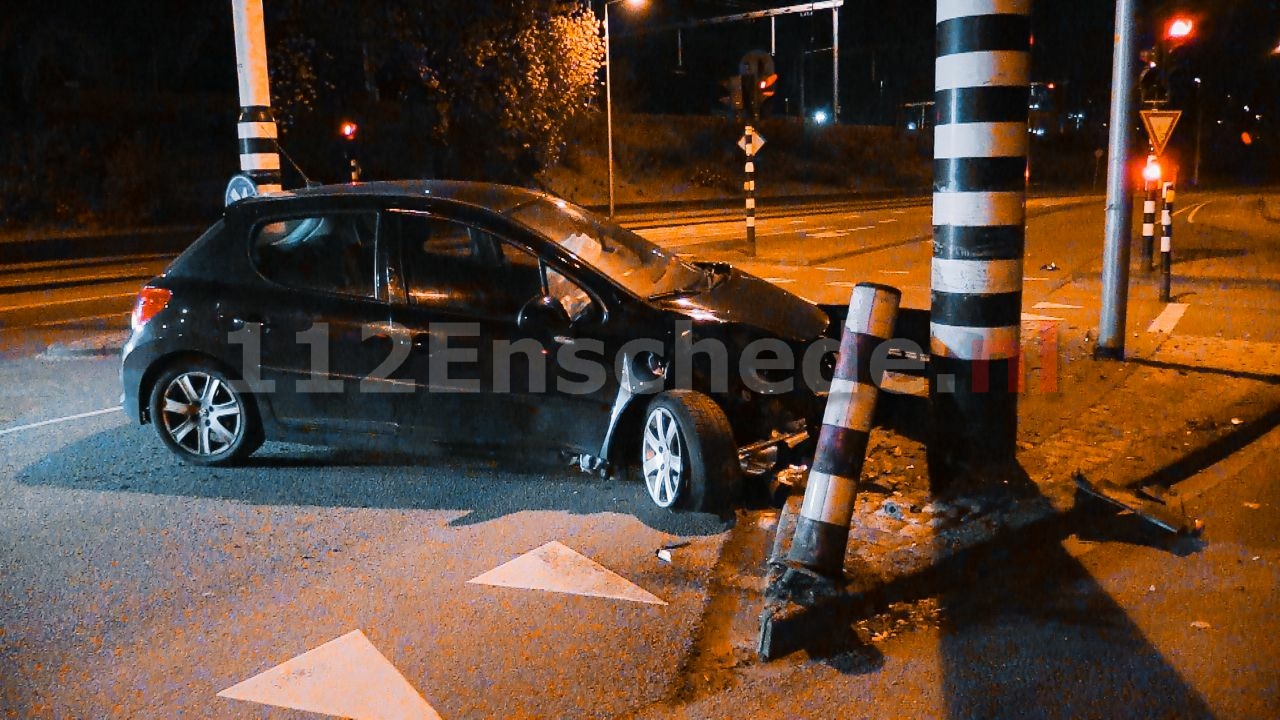 Automobilist in volle vaart tegen verkeerslicht in Enschede, onderdelen tientallen meters verderop