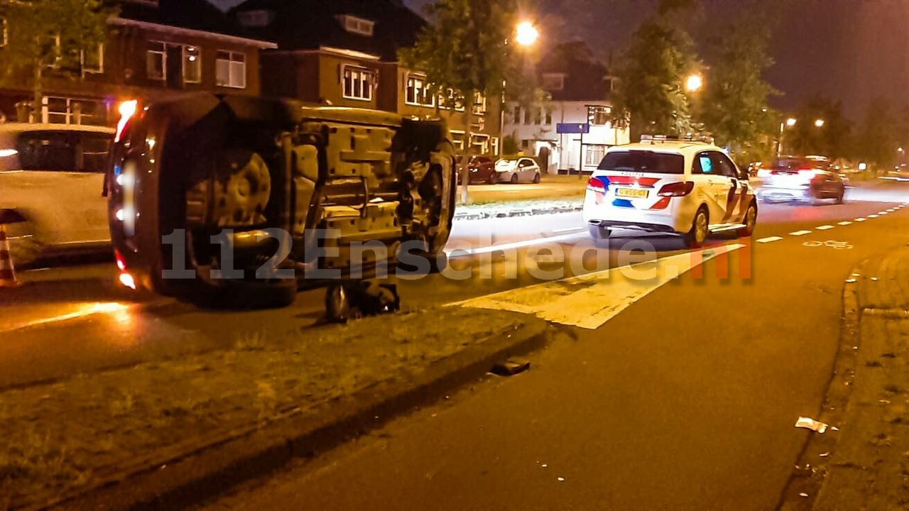 Auto op de kant na rammen verkeerslicht in Enschede