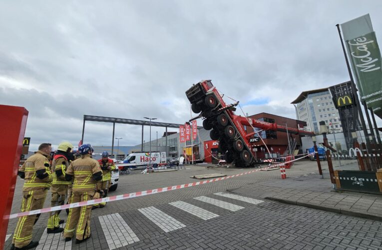 Grote kraanwagen valt om op KFC in Enschede